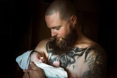 photo-of-a-tattoed-dad-holding-his-baby-by-birth-photographer-leona-darnell